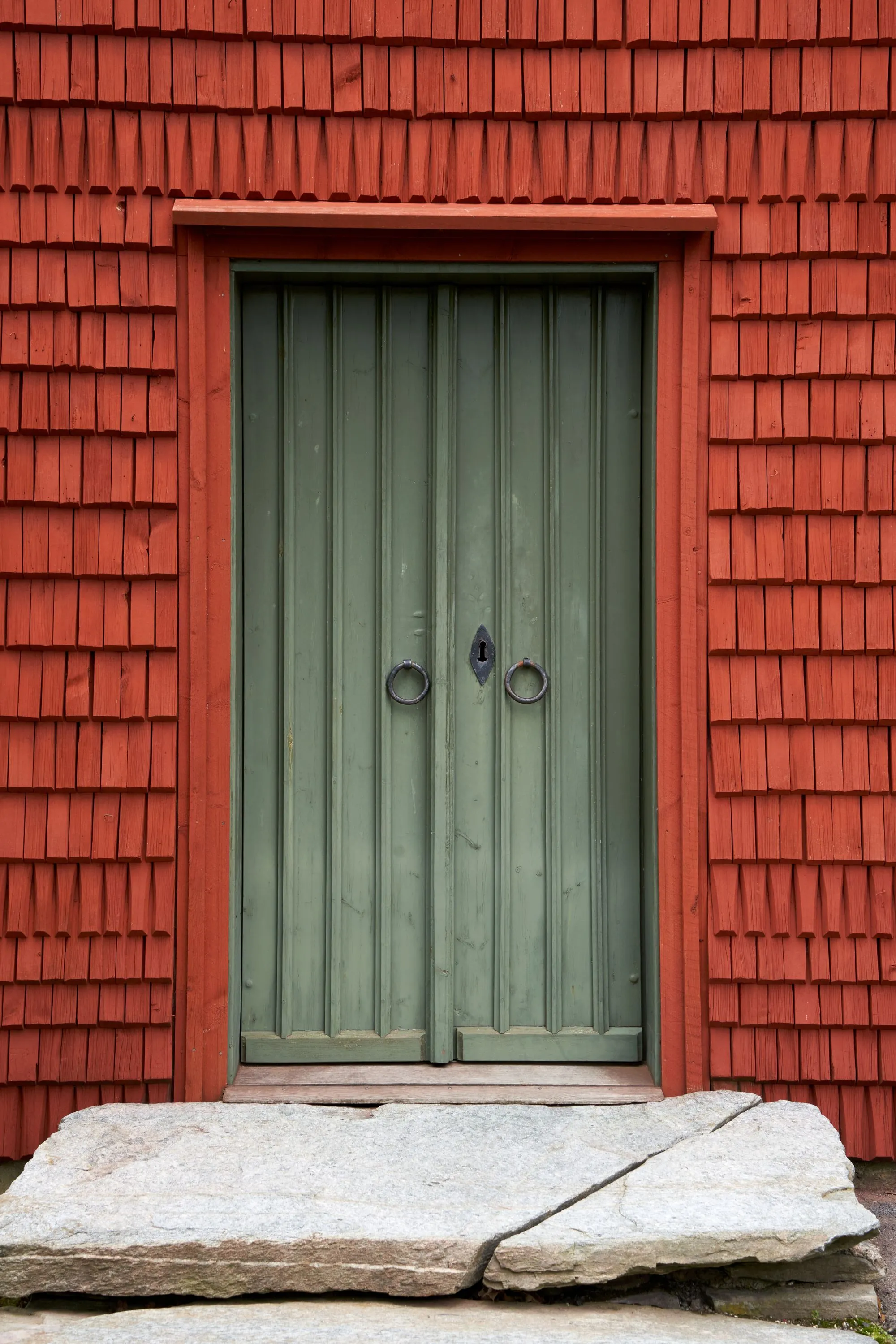 Red shingle siding and painted doors on a house wall